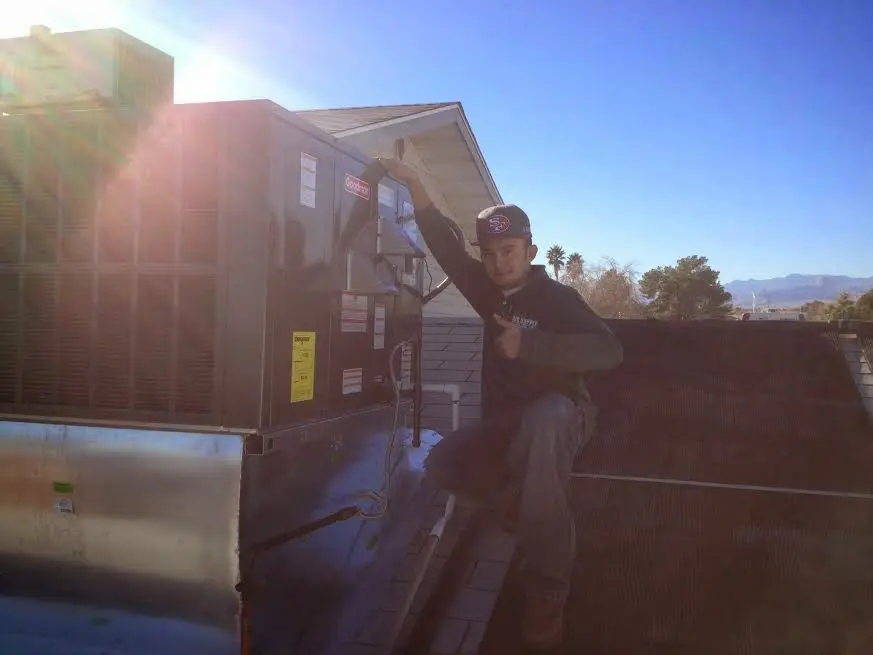 HVAC technician performing AC Tune-Up on a rooftop unit in Murraysville